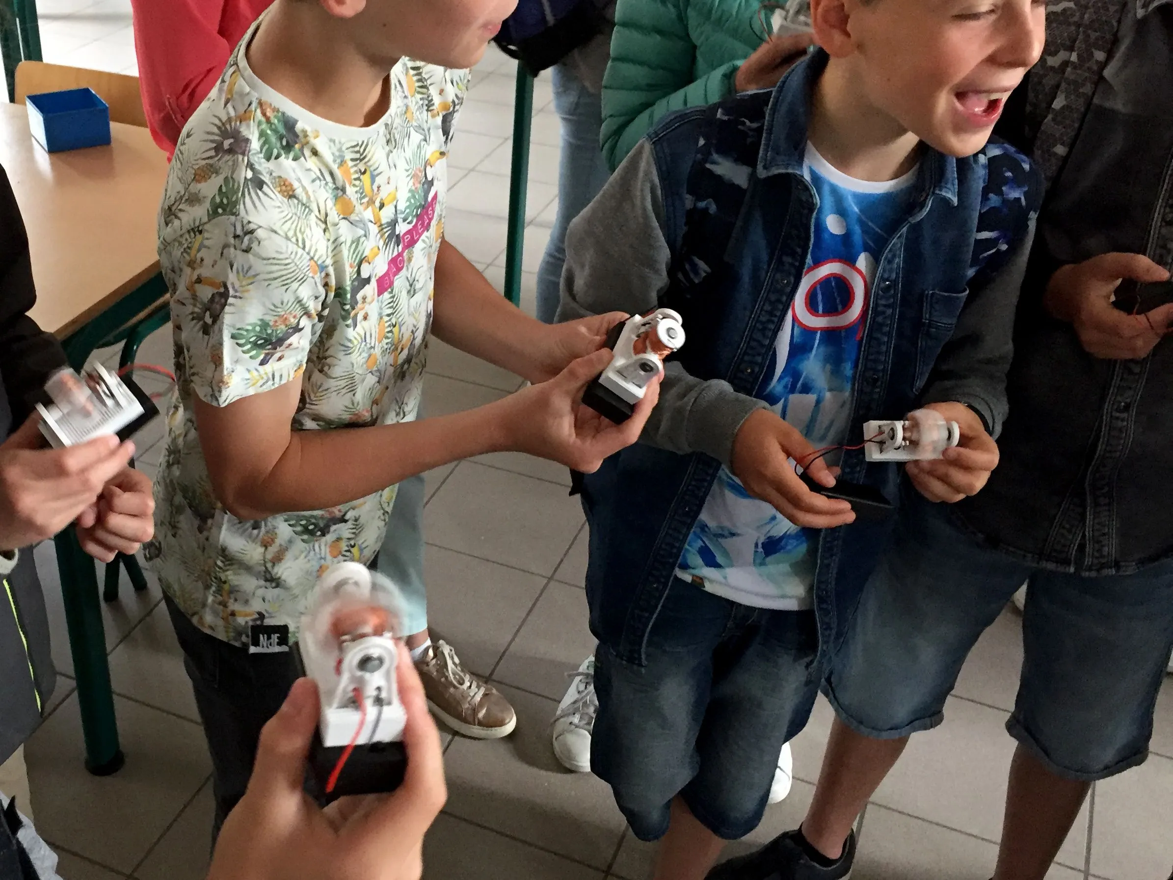 Kinderen bekijken kleine zelfgemaakte elektronica tijdens een workshop